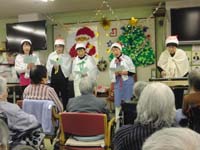 クリスマス装飾の中、入居者と職員がレクリエーション活動を行っている様子